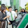 Khách hàng trải nghiệm các dịch vụ ngân hàng số mới nhất tại trụ sở mới Vietcombank Ba Đình. (Ảnh: Vietnam+)