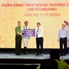 Ông Nguyễn Thanh Tùng - Phó Tổng Giám đốc phụ trách Ban điều hành đại diện Vietcombank ủng hộ Quỹ 5 tỷ đồng. (Ảnh: Vietnam+)