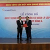 Ông Nguyễn Thanh Tùng (phải) đón nhận Quyết định của Thống đốc Ngân hàng Nhà nước. (Ảnh: CTV/Vietnam+)