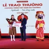 Ông Phạm Đức Tuấn Phó Tổng giám đốc Agribank trao giải Đặc biệt 01 tỷ đồng cho khách hàng. (Ảnh: Vietnam+)