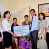 Đại diện Vietcombank Hải Dương và đại diện FWD Việt Nam thăm hỏi, tặng quà và trao biển tượng trưng chi trả quyền lợi bảo hiểm cho anh Phùng Văn Lực. (Ảnh: Vietnam+)