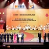 Ủy viên Ban Chấp hành Trung ương Đảng, Phó Bí thư Thành ủy, Chủ tịch Ủy ban Nhân dân thành phố Hà Nội trao Huân chương Lao động hạng Ba cho SHB. (Ảnh: PV/Vietnam+)