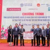 Ông Phạm Đức Ấn - Chủ tịch Hội đồng thành viên Agribank trao tặng quà của Agribank hỗ trợ hộ cận nghèo, đối tượng chính sách quận Hà Đông (Hà Nội) nhân dịp Tết Nguyên đán Giáp Thìn. (Ảnh: PV/Vietnam+)
