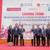 Ông Phạm Đức Ấn - Chủ tịch Hội đồng thành viên Agribank trao tặng quà của Agribank hỗ trợ hộ cận nghèo, đối tượng chính sách quận Hà Đông (Hà Nội) nhân dịp Tết Nguyên đán Giáp Thìn. (Ảnh: Vietnam+)