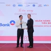 Ông Phạm Quốc Long (bên phải) - Giám đốc Trung tâm khách hàng phía Nam đại diện VietinBank nhận giải thưởng từ ban tổ chức. (Ảnh: Vietnam+)