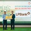 Đại diện LPBank, ông Hoàng Văn Phúc – Phó Tổng Giám đốc trao tặng biểu trưng số tiền 5 tỷ đồng cho Quỹ vì người nghèo của thành phố Thủ Đức. (Ảnh: Vietnam+)