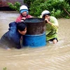 Người dân xã An Hiệp, huyện Tuy An, Phú Yên, phải dầm mình trong nước lũ. (Ảnh: Thế Lập/TTXVN)