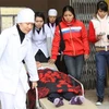 Một học sinh trường Trung học cơ sở Quán Toan được đưa đến bệnh viện (Ảnh: Vũ Văn Đức/Vietnam+)