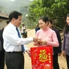Chủ tịch nước Nguyễn Minh Triết tặng quà cho các hộ gia đình phát triển chăn nuôi trâu bò có hiệu quả. (Ảnh: Nguyễn Khang/TTXVN)