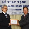Chủ tịch Liên hiệp các tổ chức hữu nghị Việt Nam Vũ Xuân Hồng trao tặng kỷ niệm chương cho ông Sato Hideaki. (Ảnh: Doãn Tấn/TTXVN)