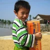 Niềm vui của em bé Can Lộc khi được nhận mỳ tôm cứu trợ. (Ảnh: Sơn Bách)