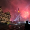Người dân đón chào Năm Mới trước tòa nhà Reichtag ở Berlin (Đức) trong màn pháo hoa rực rỡ sớm ngày 1/1/2012. (Ảnh: THX/TTXVN)
