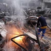 Lính cứu hỏa Palestine dập đám cháy tại một tòa nhà sau vụ không kích của Israel. (Ảnh tư liệu: AFP/TTXVN)