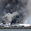 Xác chiếc Boeing 777 bị bao trùm trong cột khói nghi ngút sau khi lao xuống sân bay San Francisco. (Nguồn: bbc.co.uk)