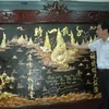 Ông Nguyễn Duy An bên cạnh tác phẩm "Thiên tải nhất thì" của mình.