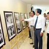Các đại biểu xem những hình ảnh về cuộc đời hoạt động báo chí cách mạnh của cố nhà báo Đào Tùng tại Tọa đàm. (Ảnh: Quốc Khánh/TTXVN)