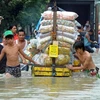 Người dân vận chuyển hàng trên một đường phố ngập lụt ở thành phố Pasig, ngoại ô thủ đô Manila của Philippines. (Ảnh: AFP/TTXVN).