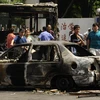 Một chiếc xe bị phá hủy trong vụ bạo động trên đường phố ở Urumqi, ngày 6/7. (Ảnh: THX/TTXVN).