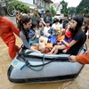Nhân viên cứu hộ sơ tán người dân khỏi các khu vực ngập lụt sau ở Marikina, phía đông Manila sau cơn bão Ketsana, ngày 27/9. (Ảnh: AFP/TTXVN).