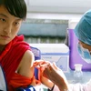 Nhân viên y tế tiêm vắcxin cho học sinh tại một trường học ở Bắc Kinh. (Ảnh: AFP/TTXVN).
