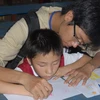 Dạy trẻ em khuyết tật vẽ tranh, tô màu. (Ảnh minh họa: Hoàng Hải/TTXVN).