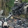 Các quan chức hàng không Ấn Độ điều tra tại hiện trường sau vụ tai nạn. (Ảnh: AFP/TTXVN). 