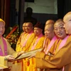 Hòa thượng Thích Thanh Tứ trao bằng tuyên dương công đức cho Hội đồng điều hành và cá nhân điều hành khóa học. (Ảnh: Nguyễn Dân/TTXVN).