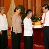 Chủ tịch nước Nguyễn Minh Triết tặng quà cho các gia đình chính sách của huyện Lương Tài. (Ảnh: Nguyễn Khang/ TTXVN).