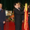 Chủ tịch nước gắn Huân chương Sao vàng lên lá cờ truyền thống của Viện Kiểm sát Nhân dân Tối cao. (Ảnh: Nguyễn Khang/TTXVN).