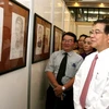 Chủ tịch nước Nguyễn Minh Triết xem các tác phẩm chân dung Mẹ Việt Nam anh hùng tại triển lãm. (Ảnh: Nguyễn Khang/TTXVN).