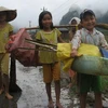 Trẻ em Tân Hóa đi lượm lặt những thứ còn sót lại trong cơn lũ vừa qua. (Ảnh: Nguyễn Đức Thọ/Vietnam+)