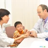 Bác sỹ Stephane Guerođang thăm khám cho trẻ bị dị tật bàn tay. (Ảnh: Minh Ánh/Vietnam+)