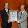 Giáo sư Phạm Đạo (phải) tặng ảnh Bác Hồ cho giáo sư Hoàng Chanh (Trung Quốc) tại Đêm hữu nghị Việt-Trung. (Ảnh: Doãn Tấn/TTXVN).