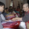 Đại diện Thành hội Phật giáo Thành phố Hồ Chí Minh tặng quà cho đồng bào. (Ảnh: Thế Anh/TTXVN).