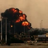 Khói lửa bốc lên sau khi máy bay ném bom của Libya bị bắn rơi ngày 19/3. (Ảnh: AFP/TTXVN)