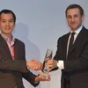 Ông Trịnh Hoài Nam, Phó Giám đốc Công ty Kiều hối Đông Á nhận giải thưởng từ đại diện của MoneyGram. (Ảnh: Hà Huy Hiệp/Vietnam+)