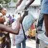 Các nạn nhân động đất Haiti nhận lương thực cứu trợ. (Nguồn: AFP/TTXVN)