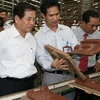 Chủ tịch nước Nguyễn Minh Triết thăm dây chuyền sản xuất gạch ngói. (Ảnh: Nguyễn Khang/TTXVN)