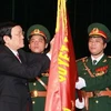 Chủ tịch nước gắn danh hiệu Anh hùng LLVTND lên lá cờ truyền thống của Tổng cục Chính trị-Quân đội nhân dân Việt Nam. (Ảnh: Nguyễn Khang/TTXVN)