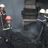 Lực lượng cảnh sát phòng cháy chữa cháy tích cực dập lửa. (Ảnh: Hồ Dung/Vietnam+)