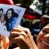 Người dân Venezuela vui mừng cầm bức ảnh Tổng thống Chavez và hai con gái. (Nguồn: Reuters)