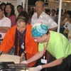Đại diện Landswork Corporation (Nhật Bản) giới thiệu thiết bị sản xuất đậu phụ tại triển lãm. (Ảnh: Hà Huy Hiệp/Vietnam+)