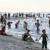 Nắng nóng, người dân đổ ra biển để giải nhiệt. (Ảnh: Hồ Cầu/TTXVN)