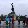 Khách du lịch đi dưới mưa ở Áo. (Nguồn: AFP)
