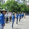 Sinh viên tình nguyện làm rào chắn đảm bảo giao thông cho thí sinh ra về tại trường Đại học Bách Khoa Hà Nội. (Ảnh: Vũ Văn Long/TTXVN)