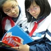 Các em học sinh Hà Nội hào hứng với cuốn sách ảnh về Trường Sa, Hoàng Sa. (Ảnh: Bích Ngọc/TTXVN)