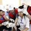 Tình nguyện viên, thanh niên, thiếu niên Chữ thập Đỏ thực hành kỹ thuật sơ cứu tại hội trại. (Ảnh: Thế Anh/TTXVN)