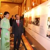 Bà Grace Fu, Bộ trưởng thuộc Văn phòng Thủ tướng Singapore (áo xanh) xem triển lãm ảnh. (Ảnh: Kim Yến/Vietnam+)