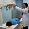 Bác sỹ sử dụng máy chụp X-quang hiện đại chẩn đoán bệnh ung thư cho người dân. (Nguồn: TTXVN)