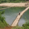 Đường vào Tà Mít, Tân Uyên, Lai Châu phải qua cây cầu tre nứa bắt qua sông Nậm Mu. Vào mùa mưa, cây cầu bị lũ cuốn trôi thì Tà Mít hoàn toàn cô lập với bên ngoài (Ảnh: Chí Bách/Vietnam+) 